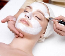 Woman receiving facial mask at beauty salon